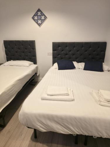 a bedroom with two beds with towels on them at Golders Park Hotel in London