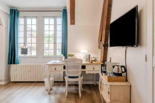 a home office with a desk and a tv at Marquise Barbot in Evry-Courcouronnes