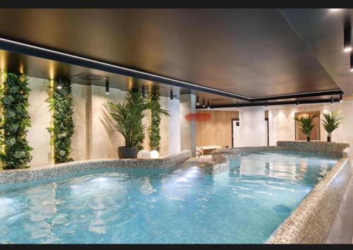 a large swimming pool in a building with plants at Baltic Waves SPA Apartament de lux A112 in Międzyzdroje