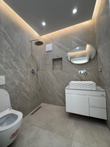 une salle de bain avec des toilettes blanches et une douche dans l'établissement Dashaj Rooms 305, à Ksamil