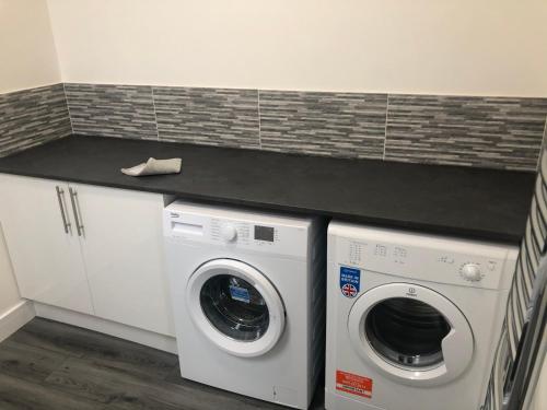 a white washer and dryer in a laundry room at 2 bedroom bungalow, 15 minutes to Alton Towers, dog friendly in Wetleyrocks