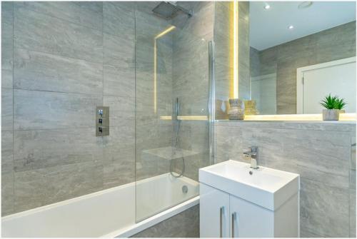 a bathroom with a shower and a sink and a tub at Modern 2 Bedrooms apartment in Central Milton Keynes Free Parking in Milton Keynes