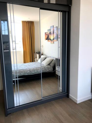 a large mirror in a bedroom with a bed at Modern 2 Bedrooms apartment in Central Milton Keynes Free Parking in Milton Keynes