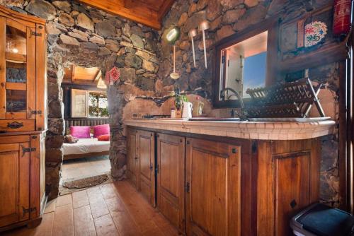 Una cocina con fregadero y una pared de piedra. en Finca rural House Tenerife Relax And Enjoy, en La Corujera