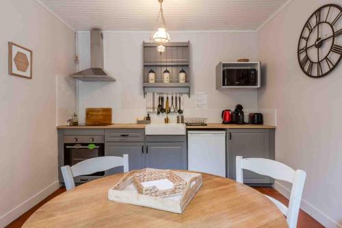 a kitchen with a table and a clock on the wall at Marquise Barbot in Evry-Courcouronnes