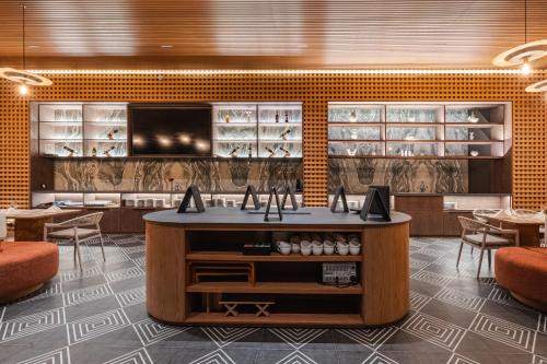a restaurant with a counter with chairs and tables at MantaHost Hotel in Manta