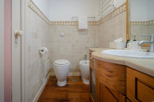 a bathroom with a toilet and a sink at Casas da Tia Alice - Casas de campo encantadoras em Mafra in Mafra
