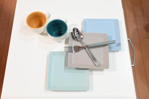 a white table with a plate with a spoon and fork and cups at Japanese Light - Vacation STAY 00130v 