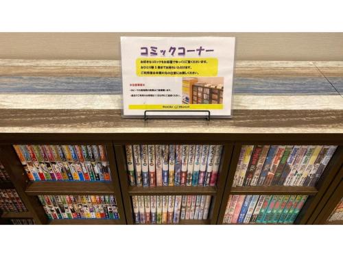 a shelf filled with dvds with a sign on it at Smile Hotel Utsunomiya Higashiguchi - Vacation STAY 00203v in Utsunomiya
