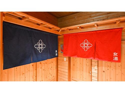 two flags are hanging on a wooden wall at Komakusa Hotel - Vacation STAY 03263v in Matsumoto
