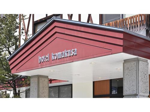 a building with a red sign on the side of it at Komakusa Hotel - Vacation STAY 03263v in Matsumoto