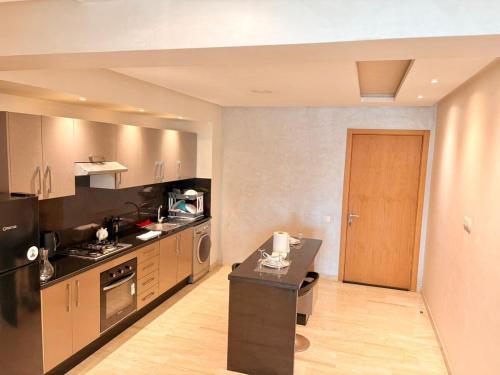 a large kitchen with a stove and a refrigerator at cozy furnished studio fully equipped in Casablanca