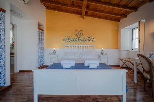 a bedroom with a large white bed in a room at Casas da Tia Alice - Casas de campo encantadoras em Mafra in Mafra