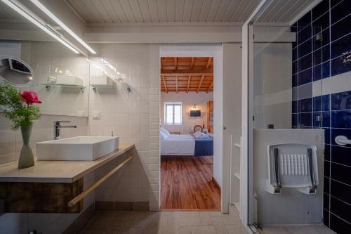 a bathroom with a sink and a toilet in a room at Casas da Tia Alice - Casas de campo encantadoras em Mafra in Mafra