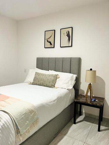 a bedroom with a bed and a side table at Marina Cerritos - Blanco Celeste - 5 Albercas in Mazatlán