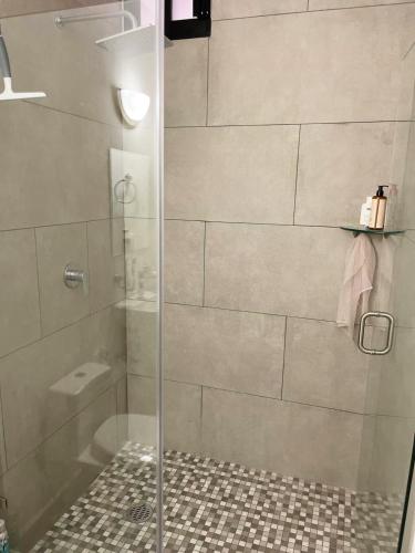 a shower with a glass door in a bathroom at Marina Cerritos - Blanco Celeste - 5 Albercas in Mazatlán