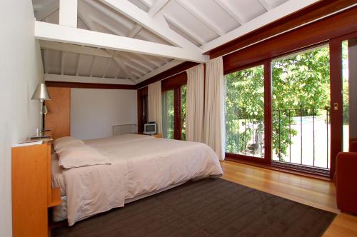 a bedroom with a bed and a large window at Casa De Alfena in Póvoa de Lanhoso