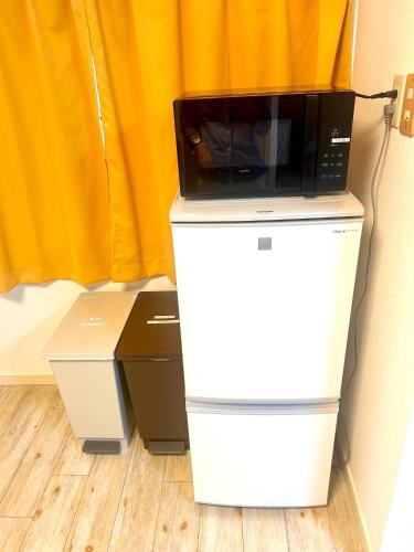 a microwave sitting on top of a refrigerator at Rodman TONE A102 - Vacation STAY 06233v in Kitakyushu