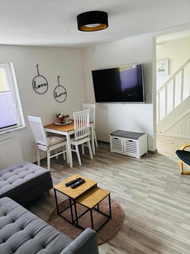 a living room with a couch and a table and a tv at Ferienhaus an der Ostsee in Ratekau