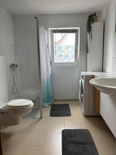 a white bathroom with a toilet and a sink at Ferienhaus an der Ostsee in Ratekau
