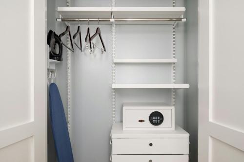 a walk in closet with a white organizer and a clock at TownePlace Suites by Marriott Ventura Oxnard in Oxnard