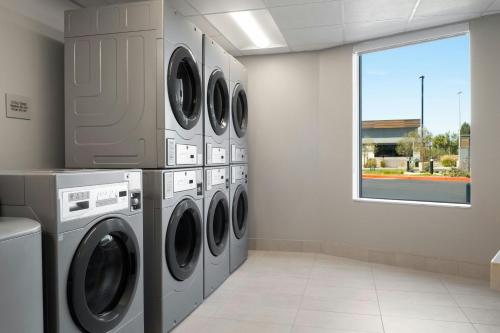 a laundry room with four washing machines and a window at TownePlace Suites by Marriott Ventura Oxnard in Oxnard