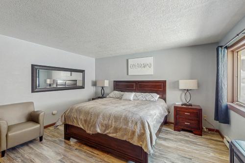 a bedroom with a bed and a chair and a window at Quicksilver 1654 in Keystone