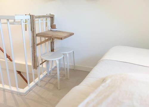 a bedroom with a bed and a table and stools at Studio No3 in Katwijk aan Zee