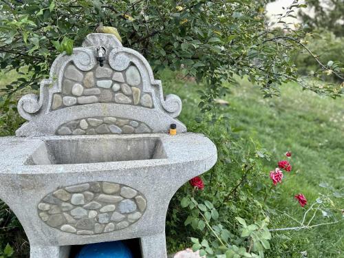a stone bird bath sitting in a garden at Curovac Nature in Ilidža