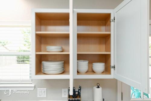 a kitchen cabinet filled with plates and dishes at Rex Ranch Comfortable and Close to Everthing in Abilene