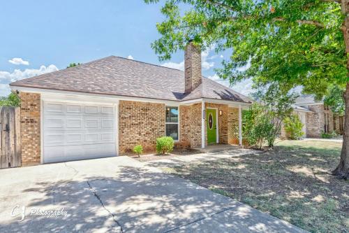 a brick house with a garage and a tree at Rex Ranch Comfortable and Close to Everthing in Abilene