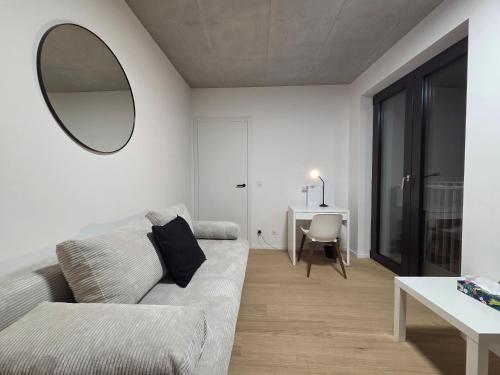 a living room with a couch and a mirror at Haas Apartments Art with parking, bakery, coffea in Brno