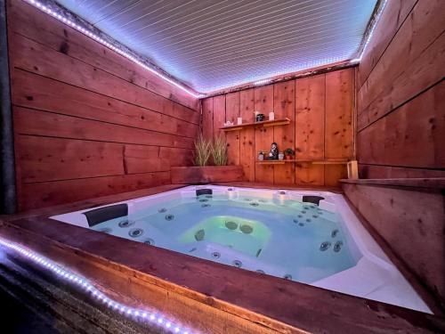 a jacuzzi tub in a room with wooden walls at Doux Pavillon - L'évasion - Jacuzzi & Sauna in Tassin-la-Demi-Lune
