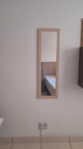 a mirror on a wall with a bed in a room at Apartamento em Santos in Santos