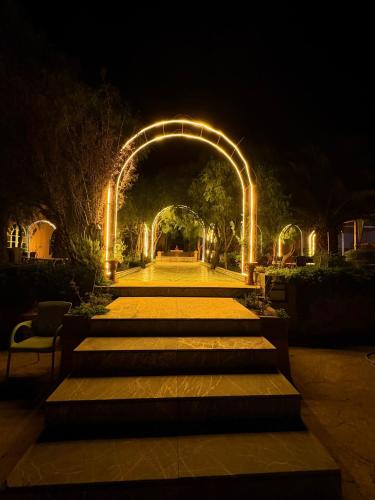 a pathway with an arch with lights at night at Hotel Kasbah Asmaa in Midelt