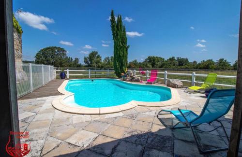 - une piscine entourée de chaises colorées dans l'établissement Gîte avec piscine, à Graulhet