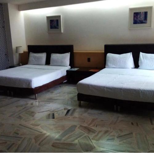 two beds in a hotel room with two beds at Hotel King Versalles in Cali