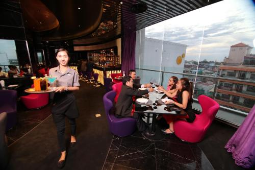 a group of people sitting at tables in a restaurant at SUN & MOON, Urban Hotel in Phnom Penh