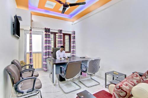 a woman sitting at a table in a room with chairs at HOME 78802 Balaji Bhawan Jhajra in Dehradun