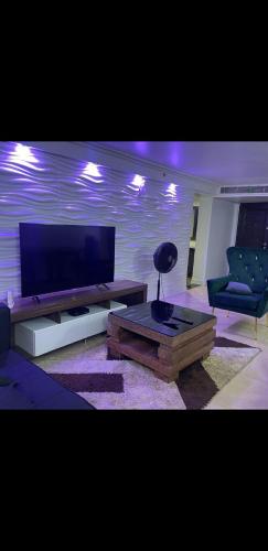 ein Wohnzimmer mit Flachbildfernseher und Couch in der Unterkunft Chinedu Apartment in Lagos