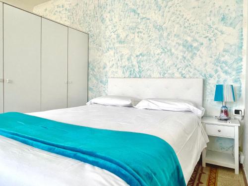 a bedroom with a bed with a blue blanket on it at Family Groups JSuite Sea View in Vernazza