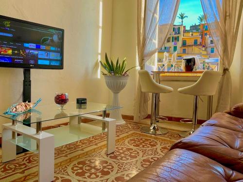 a living room with a couch and a tv at Family Groups JSuite Sea View in Vernazza