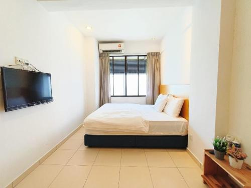 a bedroom with a bed and a flat screen tv at PD Lagoon Paradise South H-G-1 in Port Dickson