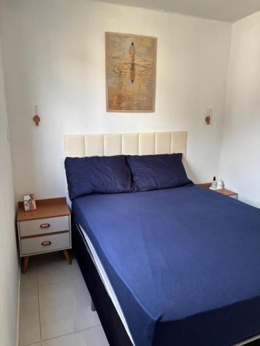 a bedroom with a blue bed and a night stand at Apartamento COP 30 Belém do Pará in Ananindeua