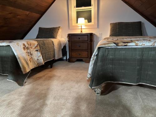 a attic bedroom with two beds and a night stand at Lake Eagle Rock Lodge in Eagle Rock