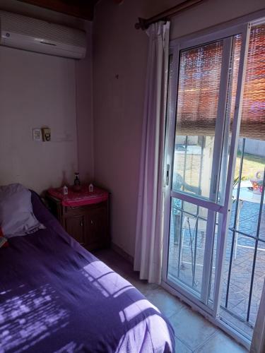 a bedroom with a bed and a sliding glass door at Habitación en zona de Bodegas a unos pocos kilómetros de Potrerillos in Ciudad Lujan de Cuyo