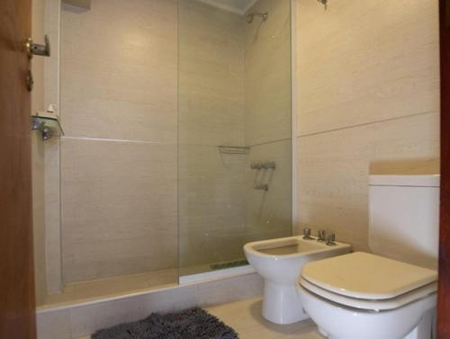 a bathroom with a toilet and a shower at Casa de Piedra Mar de las Pampas in Mar de las Pampas