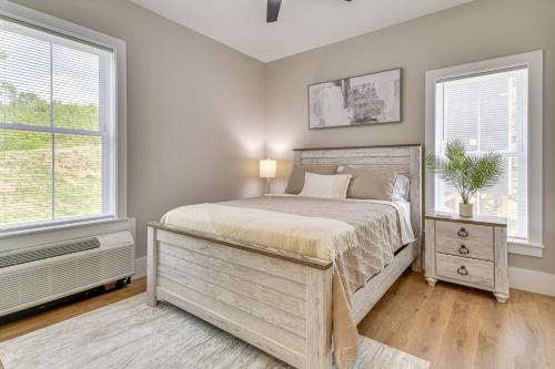 a bedroom with a large bed and two windows at Mtn Views and Stunning Fall Hikes Maggie Valley Apt in Maggie Valley