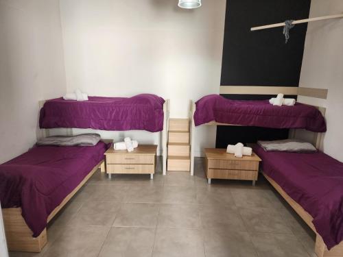 two beds in a room with purple sheets at Casa centrica, cómoda y amplia in Corrientes