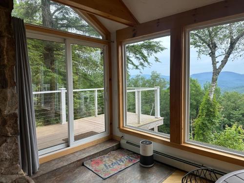a screened in porch with windows and a deck at Campton Mountain Ski Retreat for Year-Round Fun -Best view and Best Price Guarantee in Campton
